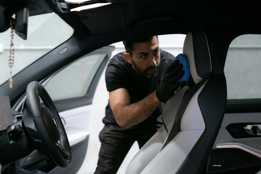 Worker cleaning a car's upholstered seat