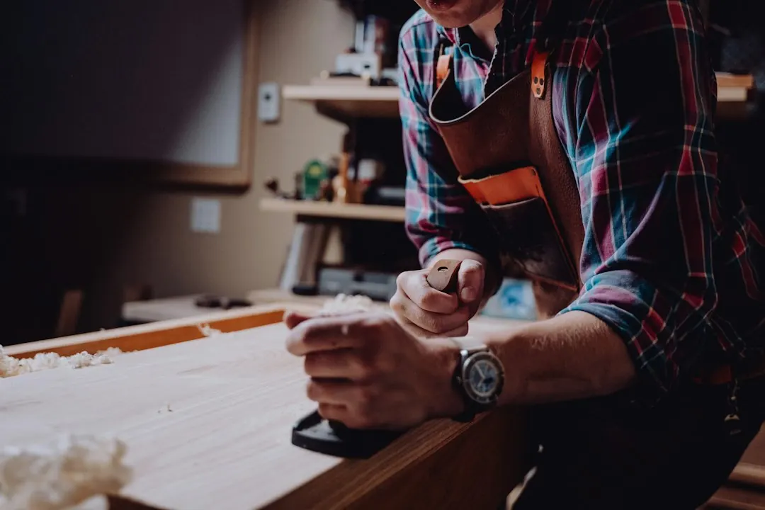 Editorial photograph of a carpenter working with timber in a workshop