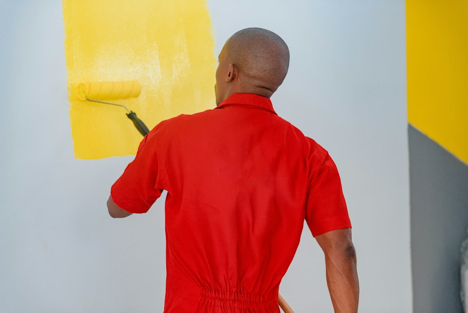 Painter applying paint with a roller on an interior wall