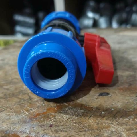 Blue and black polyethylene compression ball valve with red handle, 25mm size, photographed in store